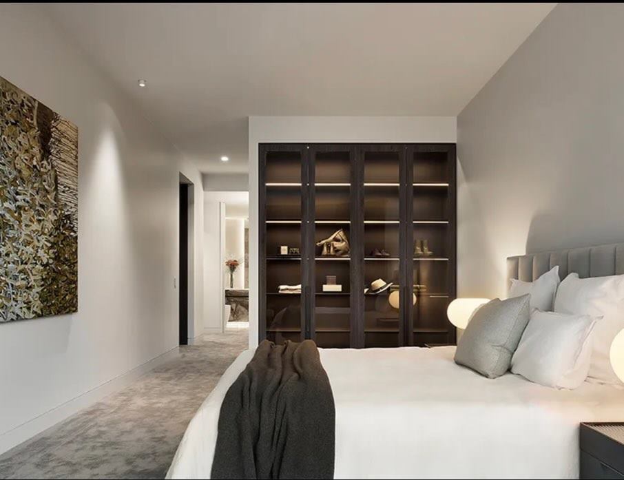 Bedroom with dark timber built-in joinery and wardrobes against pale walls.