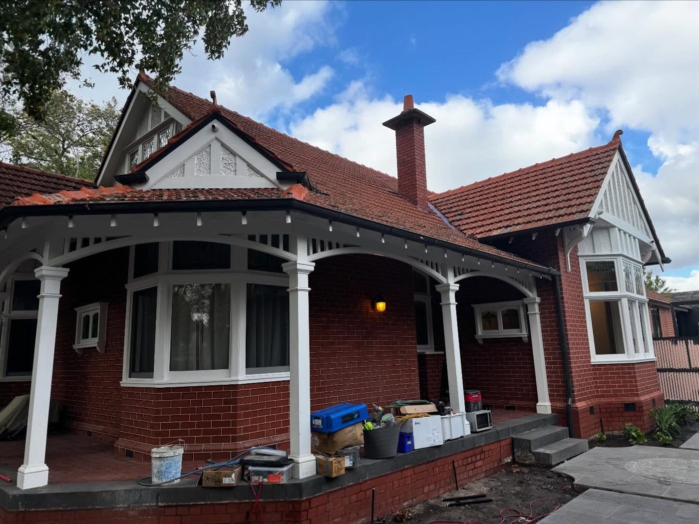 Edwardian red-brick facade with white timber trim, verandah and terracotta roof after repainting.